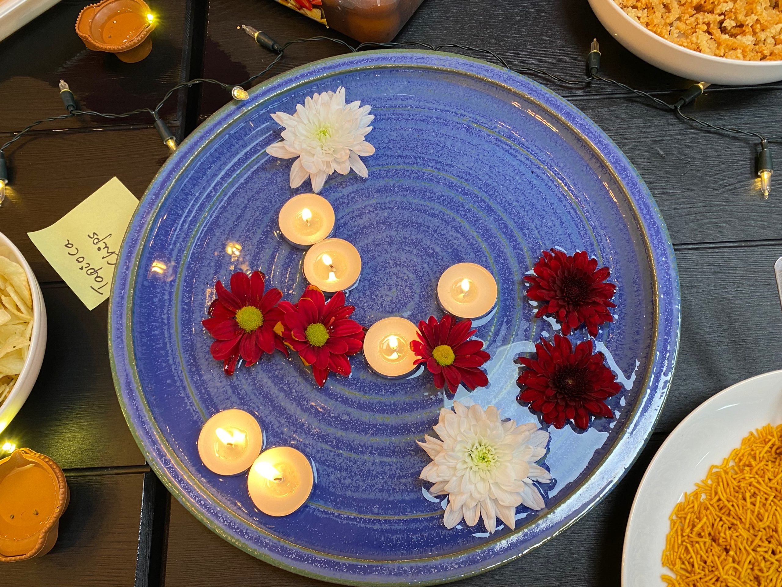 Decorative flowers and candles in water on a plate