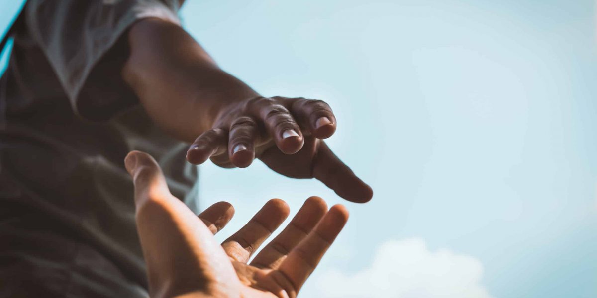 Help Concept hands reaching out to help each other in dark tone
